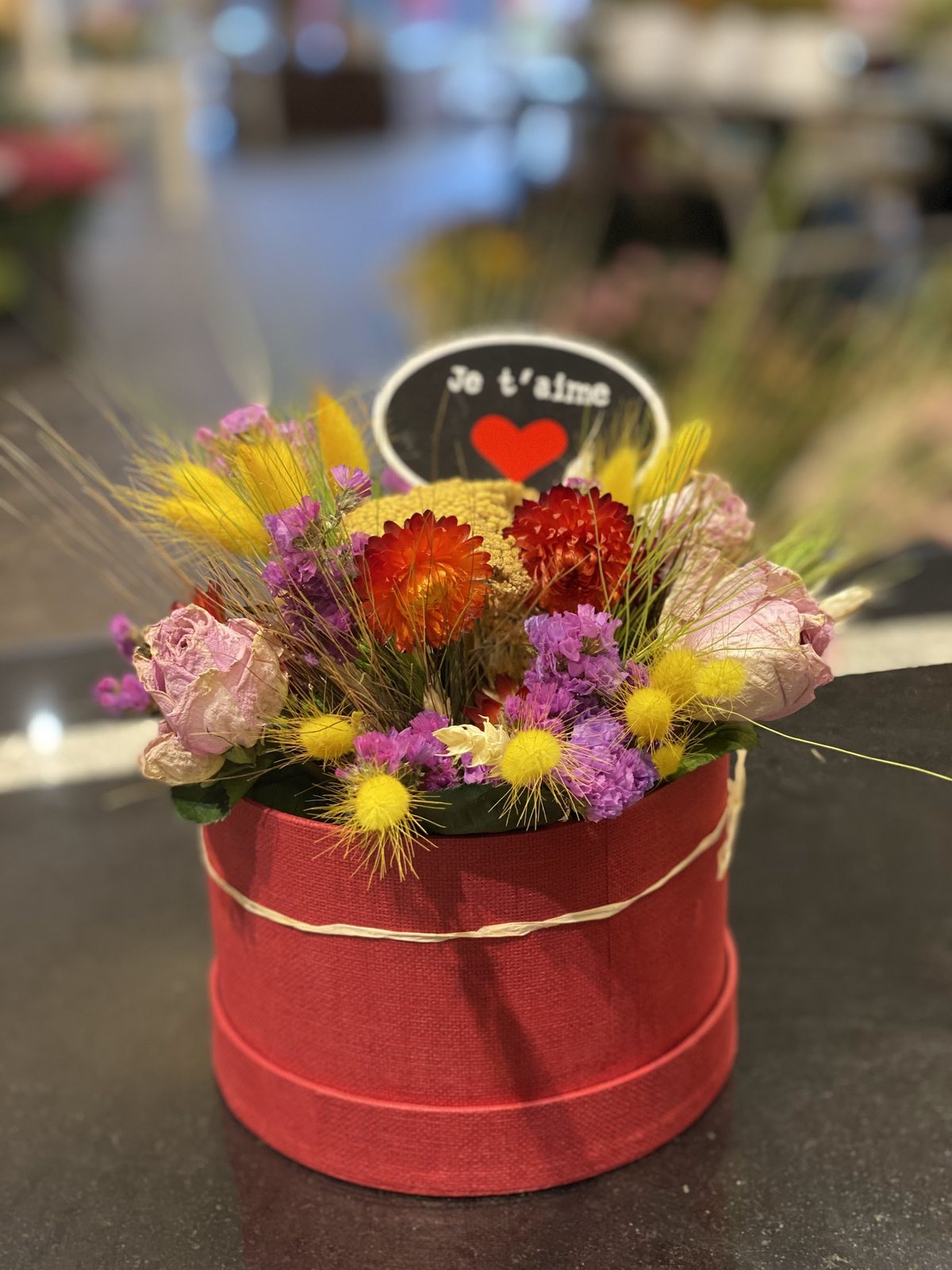 Boîte à chapeau garnie de fleurs colorées