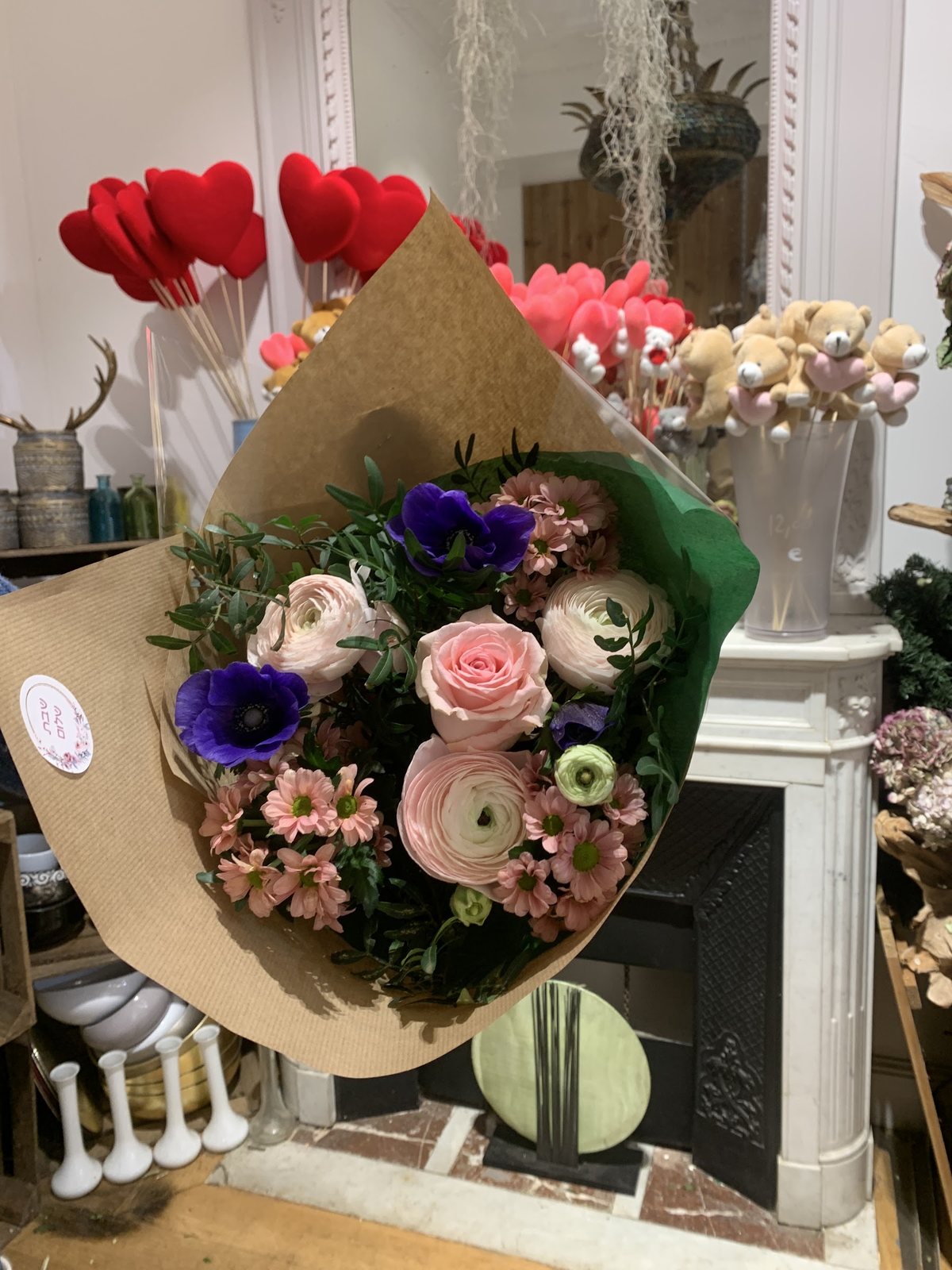 Bouquet de roses et anémones emballé dans du kraft